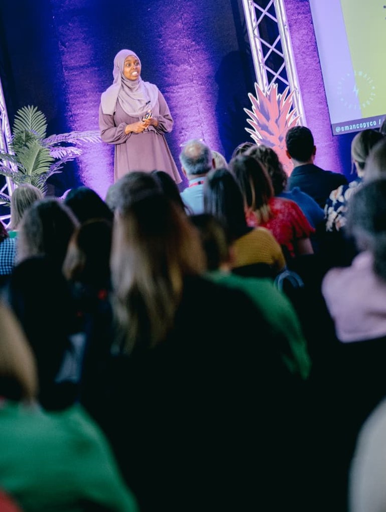Eman Ismail speaking on stage to a conference audience